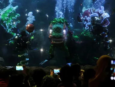Pengunjung Wahana Seaworld Ancol melihat pertunjukan kesenian Barongsai di air saat perayaan imlek 2567, Jakarta, Senin (8/2). Atraksi barongsai ini merupakan rangkaian "Chinese Fantasy Parade" di Taman Impian Jaya Ancol. (Liputan6.com/JohanTallo)