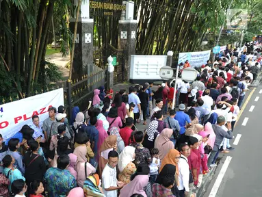 Warga antre masuk ke dalam Istana Bogor saat kegiatan open house Presiden Joko Widodo di Jalan Ir.H.Djuanda, Bogor (15/6). Ribuan warga antre untuk bersalaman mengucapkan selamat Idul Fitri  1439 H. (Merdeka.com/Arie Basuki)