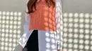 Untuk tampilan smart casual, bisa padukan kemeja dengan vest warna peach. Supaya makin stunning, kombinasikan pula OOTD-mu dengan leather skirt (Instagram/hi_sseulgi).