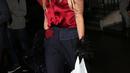 Penyanyi nyetrik Lady Gaga dengan menggunakan blus berwarna merah, celana hitam dan sepatu tinggi membawa kantung plastik putih berisi 4 kaleng bir di sebuah toko di London, Inggris. (Dailymail)