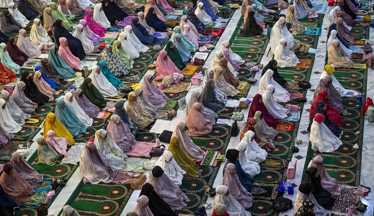 Area ruang utama hingga selasar Masjid Al Akbar, Surabaya, Jawa Timur, dipenuhi jamaah laki-laki dan perempuan, mulai dari anak-anak, remaja, hingga lanjut usia (lansia). Tampak dalam foto, umat Muslim saat melaksanakan salat Tarawih perdana di bulan suci Ramadan 1447 Hijriah di Masjid Al Akbar, Surabaya, Jawa Timur, pada Rabu 18 Februari 2026. (JUNI KRISWANTO/AFP)