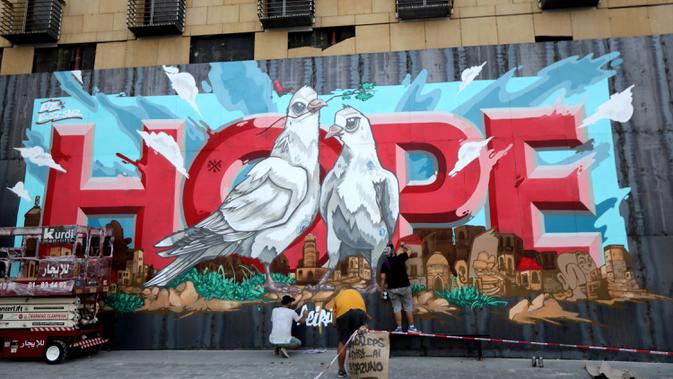 Para seniman mengerjakan mural yang menggambarkan Kota Beirut dengan kata 