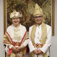 Dubes Indonesia untuk Inggris Desra Percaya dan istri mengenakan busana tradisional Lampung dengan kain tapis nuansa emas yang mewah, menyatu dengan kemegahan acara penobatan Raja Charles III. (Foto: Instagram @desrapercaya)