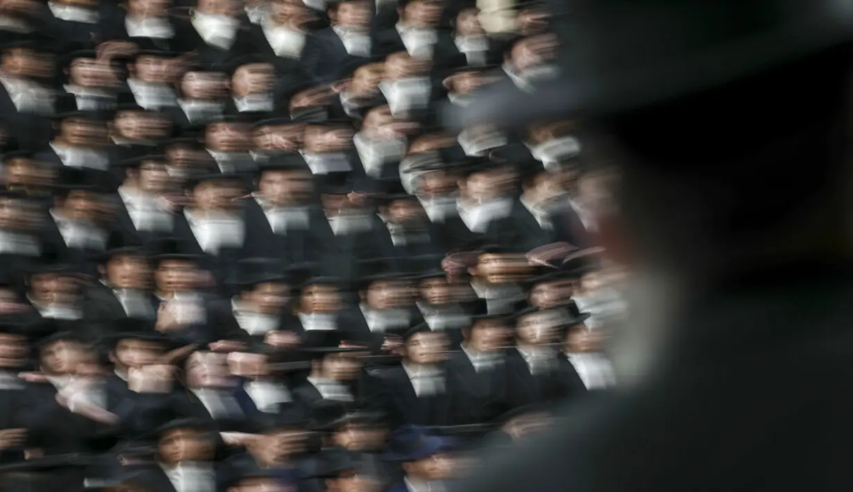 Umat Yahudi ultra-ortodoks dari dinasti Sadigura Hasidic merayakan Hari Raya Tu Bishvat atau Tahun Baru Pohon di Bnei Brak, Israel, 16 Januari 2022. Pada perayaan ini mereka duduk bersama para rabi di sekitar meja panjang dengan hidangan aneka jenis buah-buahan. (AP Photo/Ariel Schalit)