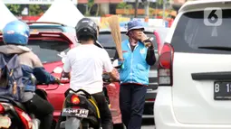 Pedagang asongan menjajakan dagangannya di Jalan Margonda Raya, Depok, Kamis (16/4/2020).  Menko Bidang Perekonomian Airlangga Hartarto mengungkap proyeksi pemerintah terhadap angka kemiskinan naik dari 9,15 persen menjadi 9,59 persen akibat pandemi COVID-19. (Liputan6.com/Helmi Fithriansyah)