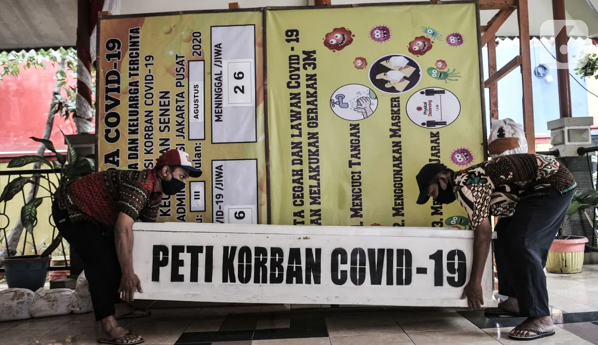 Pekerja mengangkat peti mati untuk dipajang di Kantor Kecamatan Senen, Jakarta, Kamis (13/8/2020). Pemkot Jakpus menyiapkan peti mati dan boneka pocong di setiap kecamatan sebagai peringatan akan bahaya Covid-19 dan imbauan untuk tidak mengabaikan protokol kesehatan. (merdeka.com/Iqbal Nugroho)