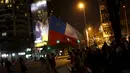 Para Suporter Chile berjalan mengibarkan bendera melewati poster penyerang Chile, Alexis Sanchez merayakan kemenangan atas Uruguay 2015 di Santiago, Chile, (25/6/2015).  Chile melaju ke semifinal usai mengalahkan Uruguay 1-0. (REUTERS/Pablo Sanhueza)