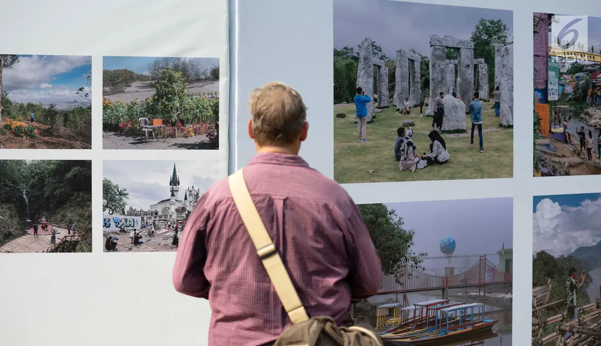 Pengunjung mengamati foto yang dipajang dalam pameran bertajuk 'Identitas' pada acara Jakarta International Photo Festival (JIPFest) 2019 di Taman Menteng, Jakarta, Rabu (3/7/2019). JIPFest 2019 dapat dinikmati di 16 lokasi pameran yang tersebar di Jakarta. (Liputan6.com/Immanuel Antonius)