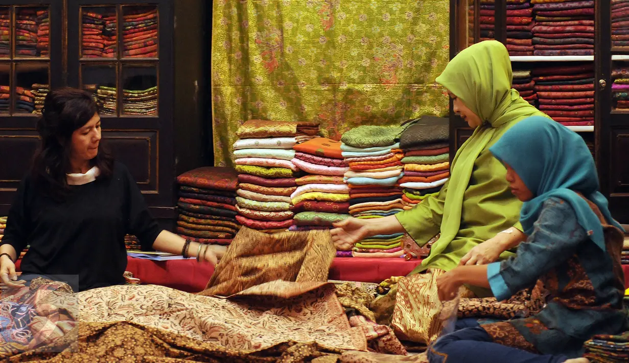 Peserta pameran merapikan deretan batik yang dipamerkan pada WARISAN 2016 di Jakarta, Kamis (25/8). Pameran ini berlangsung hingga Minggu (28/8) dan menampilkan beragam jenis batik baik tulis maupun cap original. (Liputan6.com/Helmi Fithriansyah)
