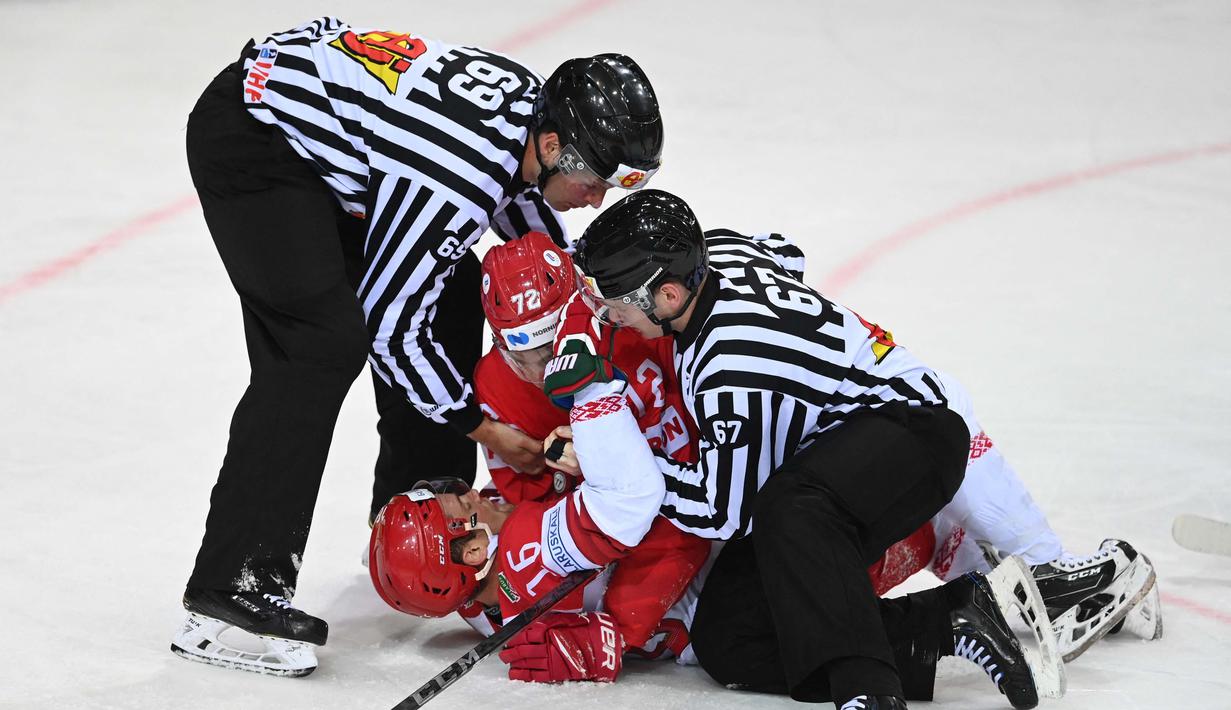 Wasit memisahkan pemain Hoki Es Rusia Emil Galimov (tengah) usai menjegal pemain depan Belarusia Geoff Platt (kiri) dalam pertandingan babak penyisihan grup A Kejuaraan Dunia Hoki Es Pria IIHF di Latvia, pada 1 Juni 2021. (Foto: AFP/Gints Ivuskans)
