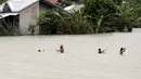 Sejumlah warga Filipina memeriksa jaring ikan yang mereka pasang saat banjir melanda wilayah mereka di Kota Condon, Ilocos sur, Filipina, Senin (24/8/2015). Banjir tersebut akibat hujan deras yang dibawa oleh Topan Goni. (AFP Photo)