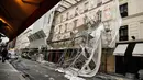 Pekerja melihat kerusakan yang terjadi usai penyangga proyek bangunan ambruk terkena angin kencang di Paris, Prancis (3/1). Tidak ada korban jiwa akibat jatuhnya penyangga proyek ini. (AFP Photo/Stephane De Sakutin)