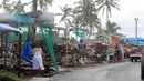 Pedagang membereskan lapak di sebuah pasar buah dan sayur yang hancur akibat diterjang badai dahsyat di Ibu kota Fiji, Suva, Senin (22/2). Badai Winston memporak-prandakan negara kepulauan Fiji hingga menewaskan sedikinya 10 orang. (REUTERS/Sarah Boxall)