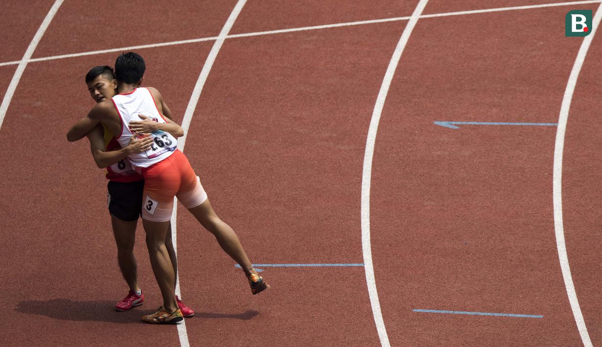 Eko Saputra asal Indonesia memeluk Phan Van Tuan dari Vietnam usai lomba para atletik nomor lari 400 meter putra klasifikasi T12 pada Asian Para Games 2018, di SUGBK, Jakarta, Kamis(11/10/2018).(Bola.com/Peksi Cahyo)