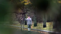 Seorang penggemar sepeda mengenakan kostum sejarah sambil menuntun Penny Farthing atau dikenal sebagai sepeda roda tinggi selama kompetisi tradisonal 'One Mile Race' di Praha, Republik Ceko pada 3 November 2018. (Photo by Michal CIZEK / AFP)
