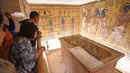 Wisatawan melihat sarkofagus emas dinasti ke-18 Firaun Tutankhamun (1332–1323 SM), ditampilkan di ruang pemakamannya di makam bawah tanahnya (KV62) di Lembah Para Raja, Luxor, Mesir (31/1). (AFP Photo/Mohamed El-Shahed)