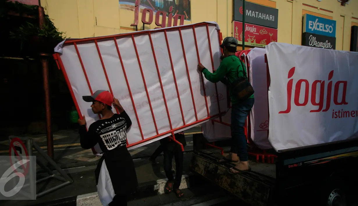 Sejumlah pekerja menurunkan pagar pembatas di kawasan pedestrian Malioboro, Senin (4/4). Terhitung sejak 4 April, kawasan Malioboro bebas dari parkir yang direlokasi ke Taman Parkir Abu Bakar Ali. (Liputan6.com/Boy Harjanto)