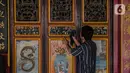 Pekerja membersihkan pintu di lingkungan Vihara Tanda Bhakti di kawasan Petak Sembilan, Glodok, Jakarta, Rabu (3/2/2021). Bersih-bersih Rumah Ibadah dilakukan untuk menyambut Hari Raya Imlek yang jatuh pada 12 Februari 2021. (Liputan6.com/Faizal Fanani)