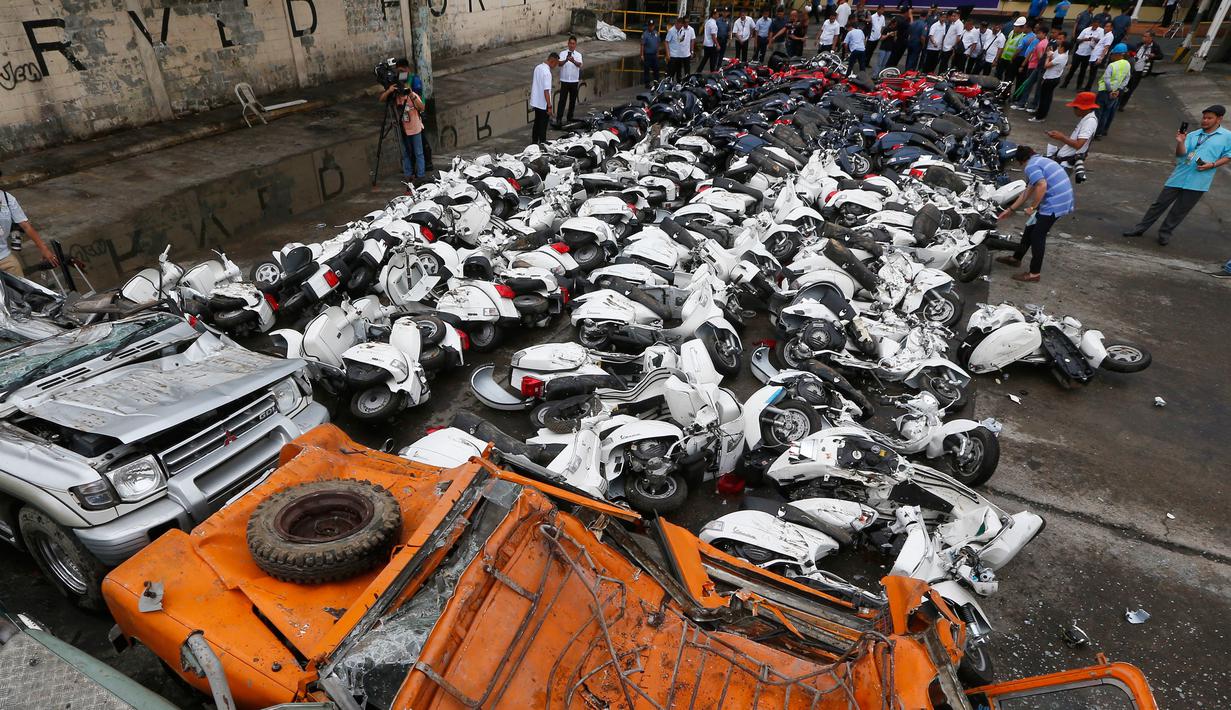 Kondisi sejumlah sepeda motor dan mobil usai dilindas ekskavator untuk dihancurkan di kantor Biro Bea Cukai di Manila, Filipina (30/5). Ratusan sepeda motor dan kendaraan hasil selundupan ini dihancurkan. (AP/Bullit Marquez)