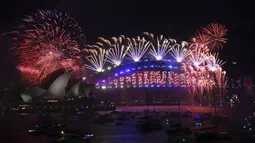 Kembang api menghiasi langit Sydney Opera House dan Harbour Bridge saat perayaan malam Tahun Baru di Sydney, Australia, Sabtu (1/1/2022). (Dean Lewins/AAP Image via AP)