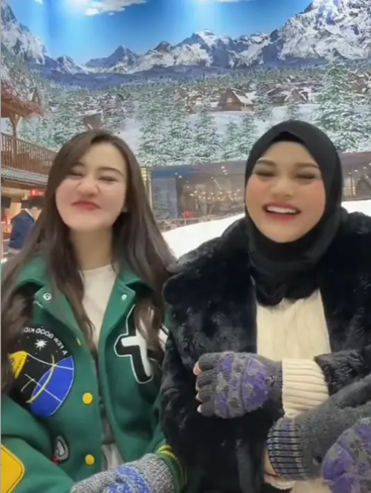 Bermain di wahana salju, Aaliyah mengenakan jaket varsity hijau. Lalu, Aurel mengenakan jaket hitam berbulu serasi dengan kerudungnya. [@aurelie.hermansyah]
