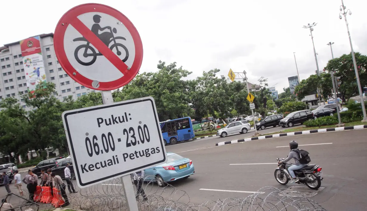 Plang pemberitahuan larangan sepeda motor melintas yang terpampang di jalan Medan Merdeka Barat, Jakarta, Selasa (7/11). Anies meminta ada perubahan agar motor bisa difasilitasi di Jalan MH Thamrin. (Liputan6.com/Faizal Fanani)