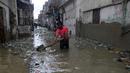 Seorang pria membersihkan jalan yang banjir setelah hujan deras, di Karachi, Pakistan, Selasa (30/7/2019). Departemen Meteorologi Pakistan mengatakan bahwa hujan memasuki provinsi Sindh dari Rajasthan India dan memperkirakan hujan akan turun tiga hari lagi. (AP Photo/Fareed Khan)