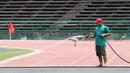 Pekerja menyiram rumput di Stadion National Olympic, Phnom Penh, Rabu (20/2). Stadion ini menjadi salah satu venue yang menggelar laga Piala AFF U-22 2019. (Bola.com/Zulfirdaus Harahap)