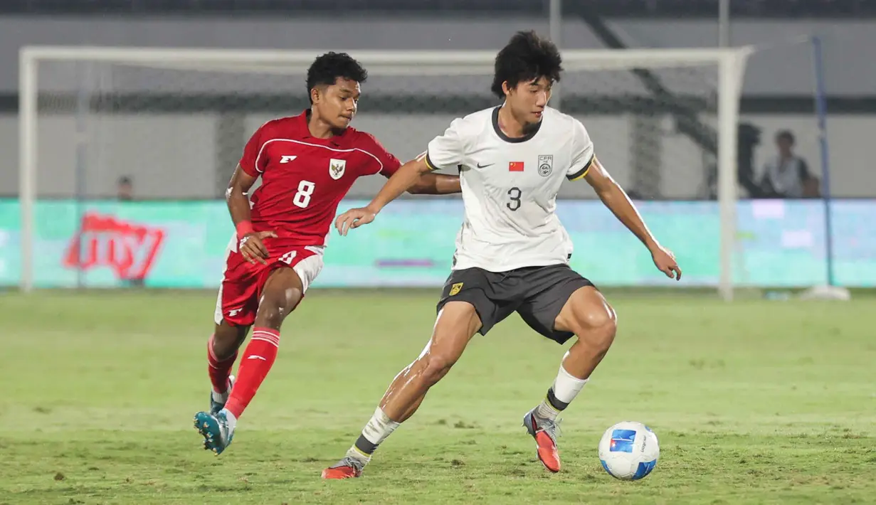 Bertanding di Indomilk Arena, Tangerang, Banten, Rabu (11/2/2026) malam, Timnas Indonesia U-17 kalah 2-3. Tampak dalam foto, pemain Timnas Indonesia U-17, Chico Jericho Yarangga (kiri) berebut bola dengan Zhao Songyuan (China) dalam laga uji coba di Indomilk Arena, Tangerang, Banten, Rabu (11/2/2026) malam. (Bola.com/Abdul Aziz)