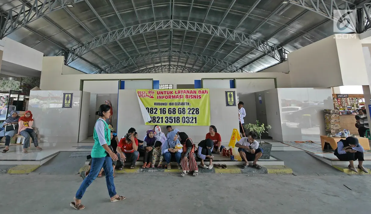 Pemudik beristirahat di depan toilet Rest Area Km 228A Tol Kanci-Pejagan, Cirebon, Jawa Barat, Sabtu (1/6/2019). Rest area ini memiliki 308 toilet dan fasilitas lainnya seperti masjid, rumah makan, dan lain-lainnya. (Liputan6.com/Herman Zakharia)