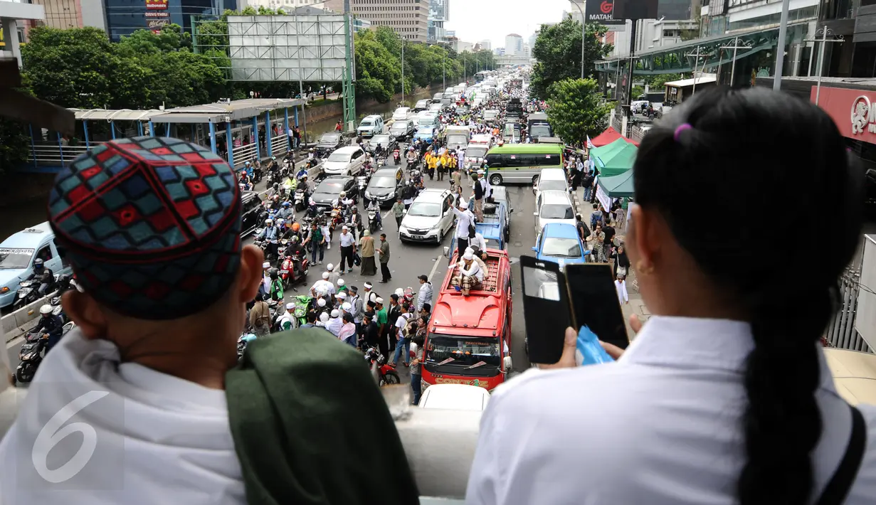 Warga menyaksikan aksi massa gabungan di depan PN Jakarta Utara saat sidang kasus dugaan penodaan agama dengan terdakwa Basuki Tjahaja Purnama, Selasa (27/12). Sidang beragendakan putusan sela dari majelis hakim. (Liputan6.com/Helmi Fithriansyah)