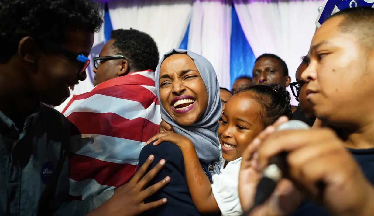 Ilhan Omar menggendong anaknya saat merayakan kemenangan pemilihan Distrik Kongres ke-5 di Minneapolis, AS, Selasa (14/8). Omar mencetak sejarah dengan memenangi putaran pertama pemilihan Distrik Kongres ke-5. (Mark Vancleave/Star Tribune via AP)