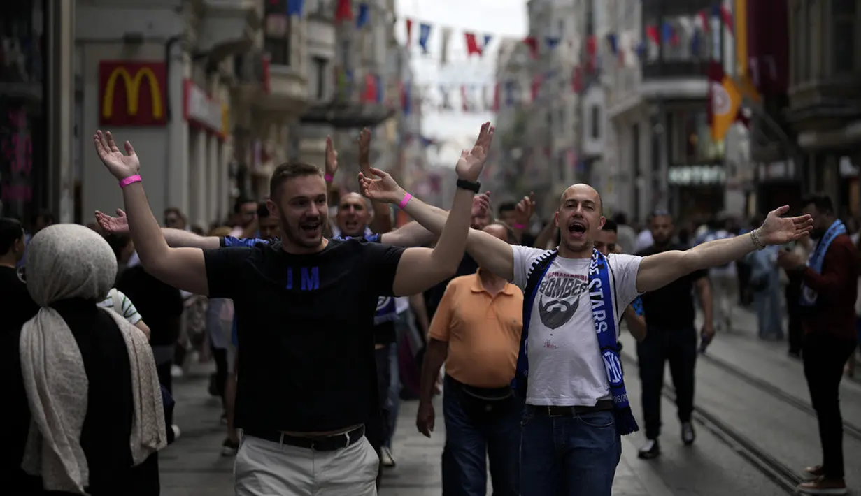 <p>Pendukung Inter Milan meneriakkan slogan-slogan saat mereka berjalan di Taksim Square. Tak ketinggalan, mereka melengkapi penampilannya dengan kaus dan syal Inter Milan. (AP Photo/Khalil Hamra)</p>
