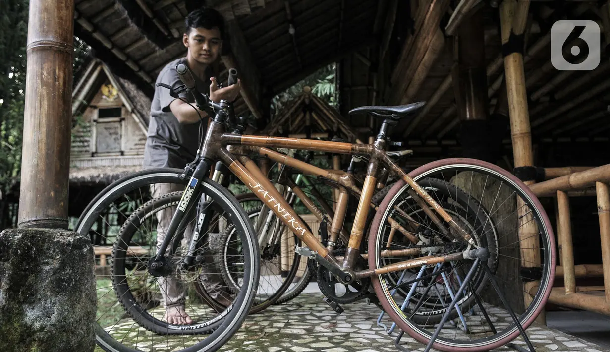 Kharis (25) mengecek sepeda bambu Jatnika di Workshop Perajin Bambu Indonesia, Cibinong, Bogor, Jawa Barat, Minggu (5/7/2020). Saat ini, Kharis meneruskan produksi sepeda bambu yang dicetus sejak 2010 oleh ayahnya, Jatnika (67). (merdeka.com/Iqbal S. Nugroho)