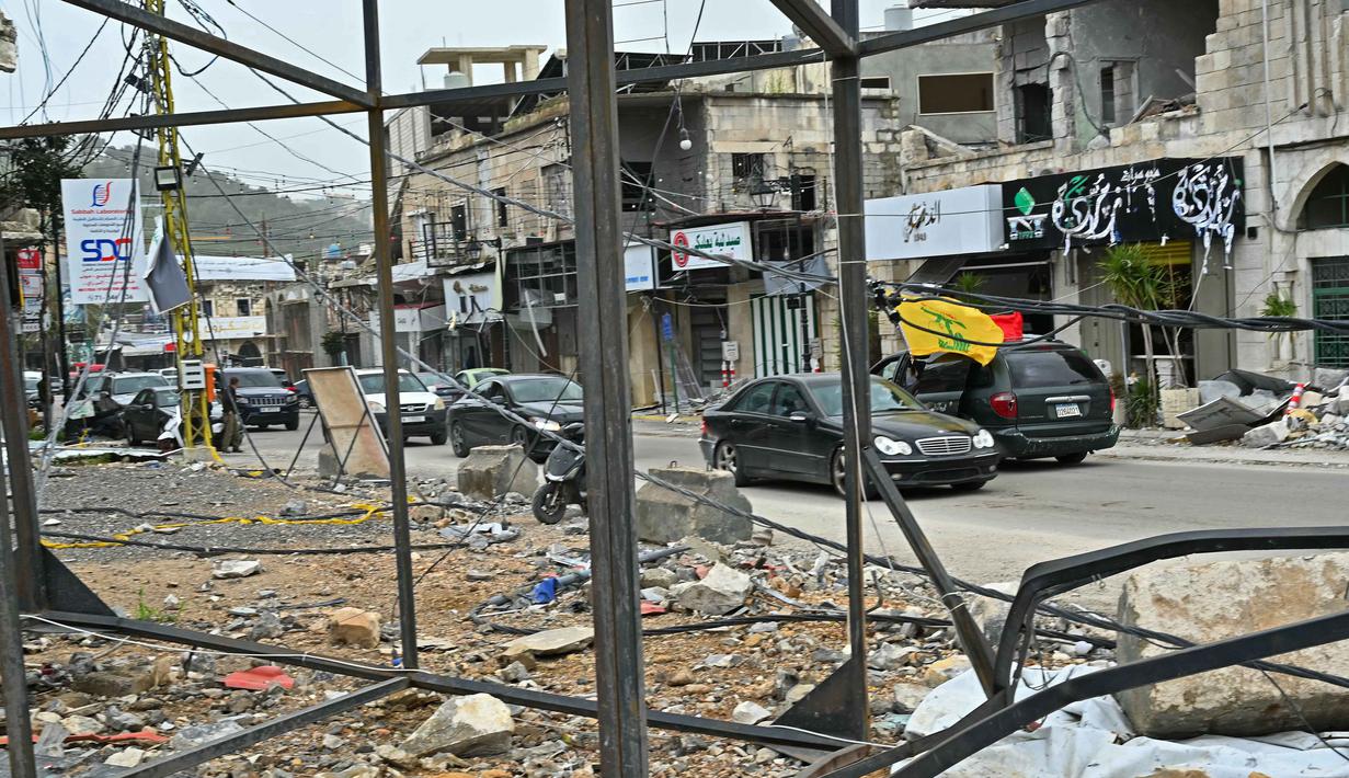 Mereka kembali setelah gencatan senjata sementara selama 10 hari diberlakukan antara Lebanon dan Israel. Tampak dalam foto, warga pengungsi berkendara melewati bangunan-bangunan yang hancur saat mereka kembali ke kota Nabatieh, Lebanon Selatan pada Sabtu 18 April 2026. (FADEL itani/AFP)