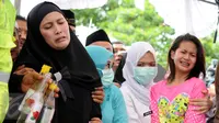Istri kedua Dodi Triono, Almianda Saphira dan sang putri Zanette Kalila Azaira (13) menangis histeris saat prosesi pemakaman jenazah korban pembunuhan Pulomas di TPU Tanah Kusir, Jakarta, Rabu (28/12). (Liputan6.com/Gempur M Surya)