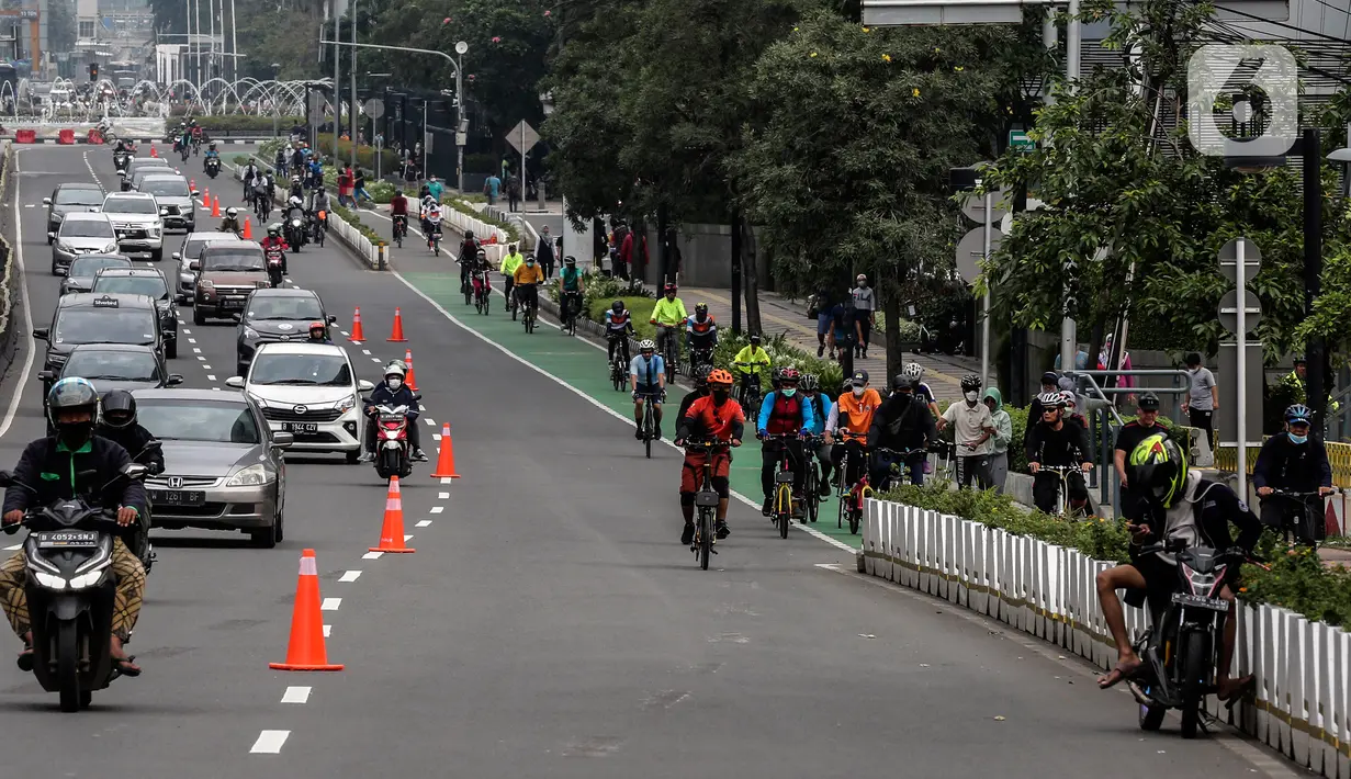 Sejumlah warga berolahraga melintas di kawasan Sudirman - Thamrin saat akhir pekan, Jakarta, Minggu (20/2/2022). Aktivitas warga di kawasan tersebut relatif ramai saat Pemberlakuan Pembatasan Kegiatan Masyarakat (PPKM) level tiga di ibu kota. (Liputan6.com/Johan Tallo)