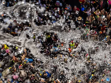 Orang-orang saling melempar air saat perang air tahunan di jalan-jalan lingkungan Vallecas, Madrid, Spanyol, 17 Juli 2022. Ribuan orang mengikuti perang air tradisional ini setelah dua tahun absen karena pandemi. (AP Photo/Manu Fernandez)