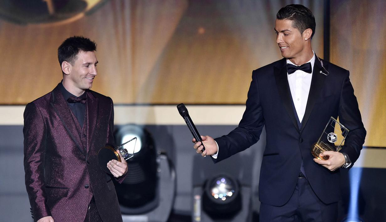 Cristiano Ronaldo memberikan microphone kepada Lionel Messi saat acara penghargaan Ballon d'Or di Zurich, (12/1/2015). (AFP/Fabrice Coffrini)