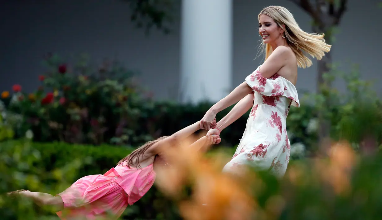 Putri Presiden AS Donald Trump, Ivanka Trump bermain dengan putrinya Arabella Kushner di Kebun Mawar di Congressional Picnic di Gedung Putih, Washington (22/6). Ivanka cantik mengenakan dress bermotif bunga dengan bahu terbuka.  (AP Photo/Alex Brandon)