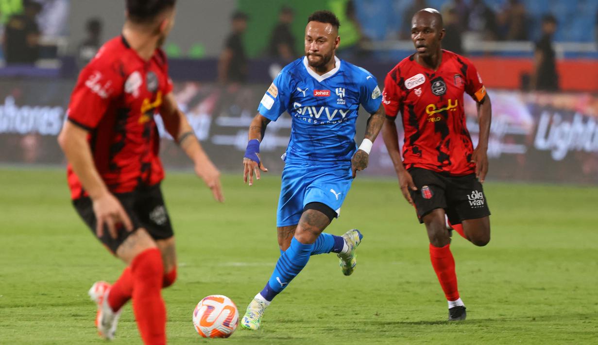 Pemain Al Hilal, Neymar (tengah) berusaha melewati adangan dua pemain Al Riyadh saat laga lanjutan Liga Arab Saudi di Prince Faisal Bin Fahd Stadium, Riyadh, 16 September 2023 dini hari WIB. (AFP/Fayez Nureldine)