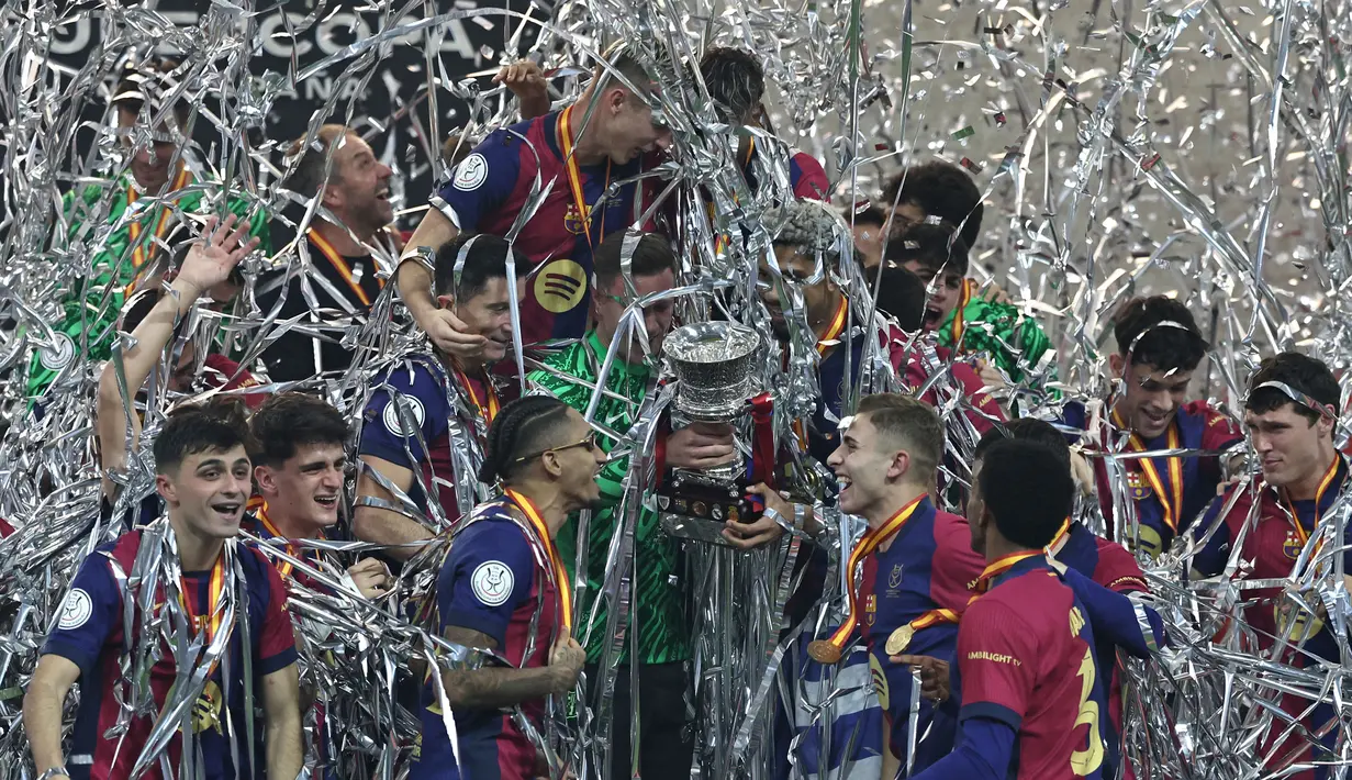 Para pemain Barcelona merayakan kemenangan dengan trofi setelah pertandingan final Piala Super Spanyol 2025 melawan Real Madrid di King Abdullah Sport City, Jeddah pada Senin (13/1/2025) dini hari WIB. (FADEL SENNA/AFP)