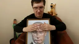 Seorang pengunjung menyentuh foto 3D Vladimir Putin di perpustakaan khusus tunanetra di Krasnoyarsk, Siberia, Rusia (15/3). Ini memudahkan warga yang tidak bisa melihat atau buta dapat mengenali sosok Putin. (REUTERS/Ilya Naymushin)