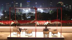 Sejumlah pengunjung duduk bersantai menikmati pemandangan perkotaan Jakarta di fasilitas Sky Garden Indonesia Arena, Senayan, Jakarta sebelum laga Grup H Piala Dunia FIBA 2023 antara Kanada melawan Latvia pada Selasa (29/08/2023). (Bola.com/Bagaskara Lazuardi)