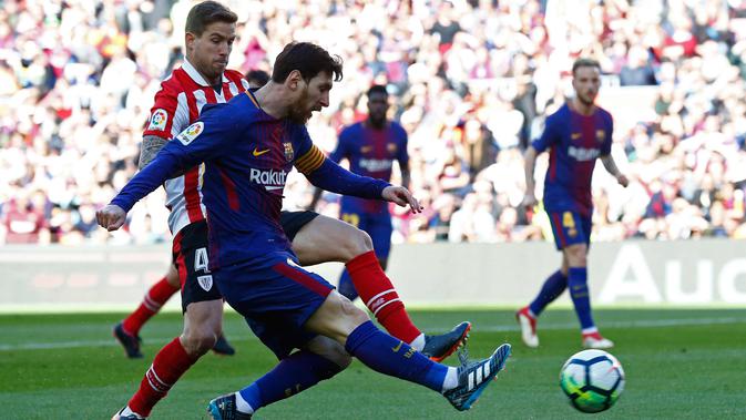 Lionel Messi mengumpan bola dari kawalan pemain Athletic Bilbao saat bertanding pada lanjutan La Liga Spanyol di stadion Camp Nou, (18/3). Pada pertandingan ini, Messi terlihat berjoget usai mencetak gol. (AP Photo/Manu Fernandez)