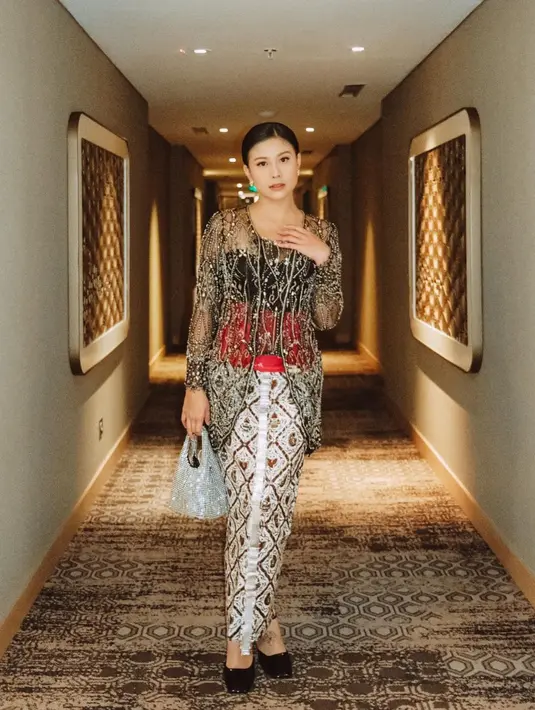 Selebgram Karin Novilda atau Awkarin turut hadir mengenakan kebaya  berpayet dan kain batik dari @anarav.label. Kebaya tersebut dipadukan dengan bustier dan stagen warna merah. [Instagram/narinkovilda]