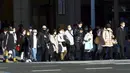 Orang-orang yang mengenakan masker pelindung untuk membantu mengekang penyebaran COVID-19 berjalan kaki di Tokyo, Jepang, Kamis, (4/2/2021). Tokyo mengonfirmasi lebih dari 730 kasus baru COVID-19 pada 4 Februari 2021. (AP Photo/Eugene Hoshiko)