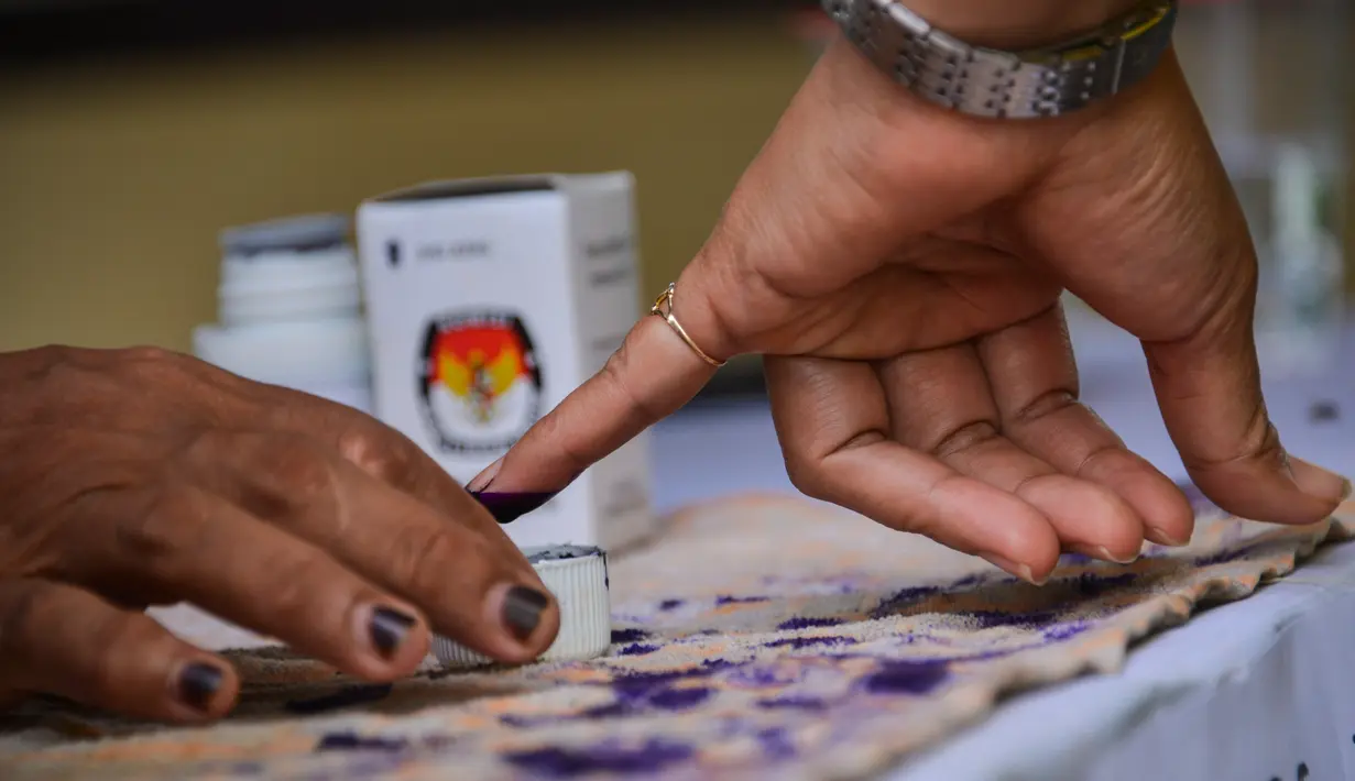 Warga mencelupkan jarinya ke dalam tinta usai mencoblos pada pemungutan suara ulang pemilu 2019 di TPS-6 Desa Lamteumen Timur, Banda Aceh, Aceh, Kamis (25/4). Pemungutan suara ulang karena adanya penggunaan formulir C6 pemilih yang telah meninggal pada pemilu 17 April lalu. (CHAIDEER MAHYUDDIN/AFP)
