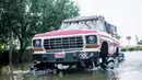 Warga menurunkan barangnya truk raksasa saat kembali ke rumah mereka di Port Arthur, Texas, AS (1/9). Truk raksasa ini menjadi salah satu kendaraan yang diandalkan usai Badai Harley menghantam Texas. (AFP Photo/Emily Kask)