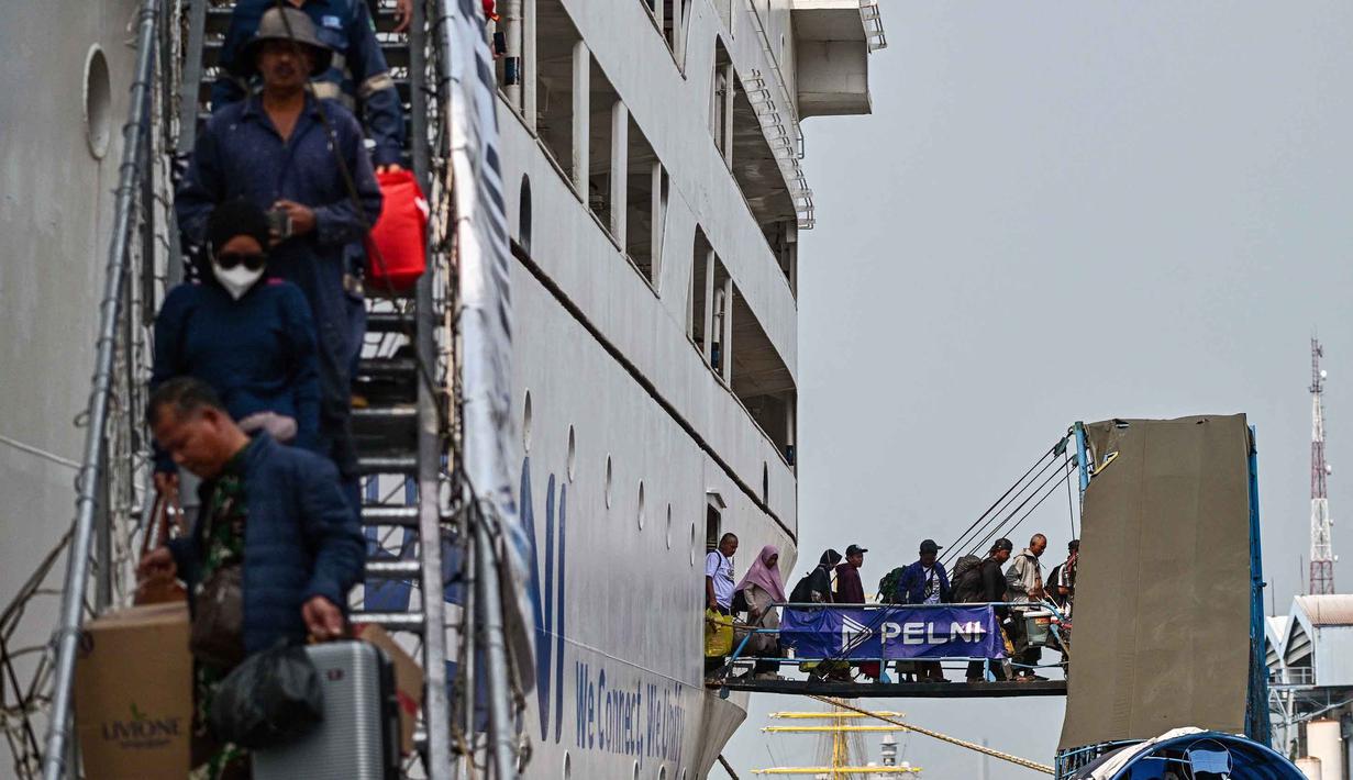 Untuk diketahui, arus mudik Lebaran 2026 di Pelabuhan Tanjung Perak, Surabaya, mulai terlihat sejak Selasa 10 Maret 2026. Tampak dalam foto, para penumpang berjalan keluar untuk turun dari kapal di pelabuhan Perak, Surabaya, Jawa Timur pada Minggu 15 Maret 2026. (JUNI KRISWANTO/AFP)